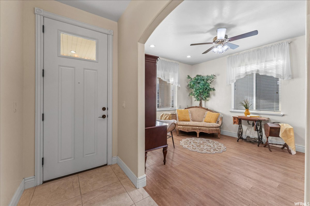Entryway with light tile flooring, a wealth of natural light, and ceiling fan