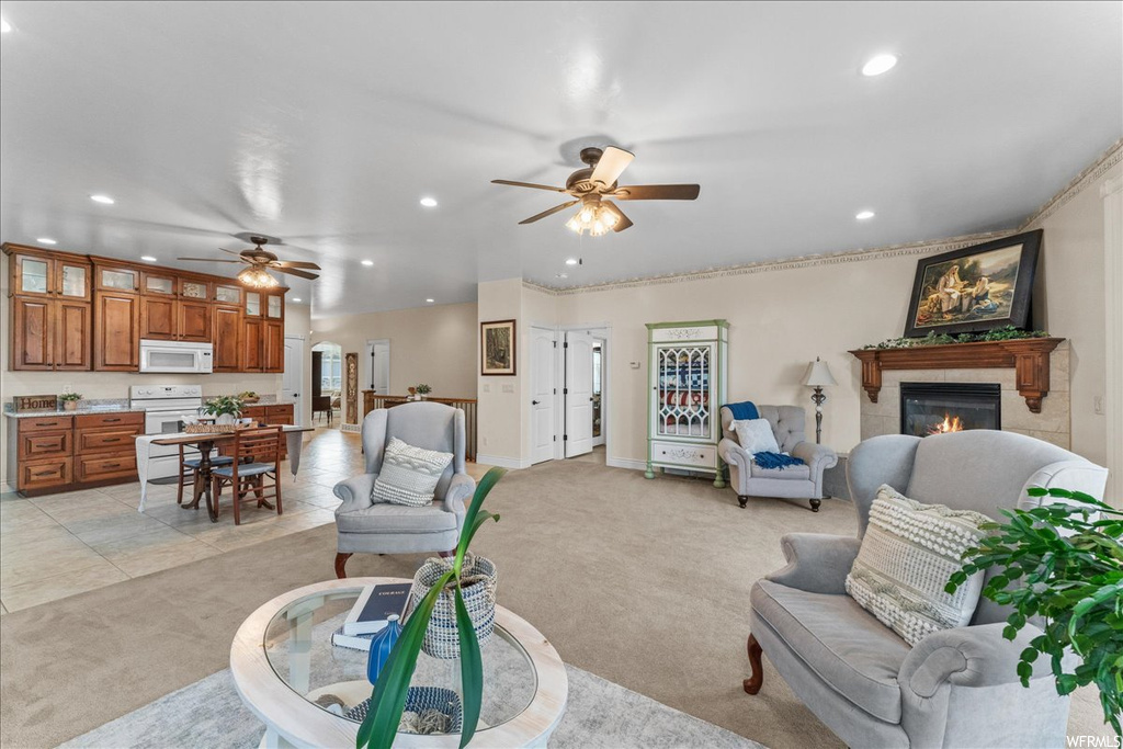 Carpeted living room with a tile fireplace and ceiling fan