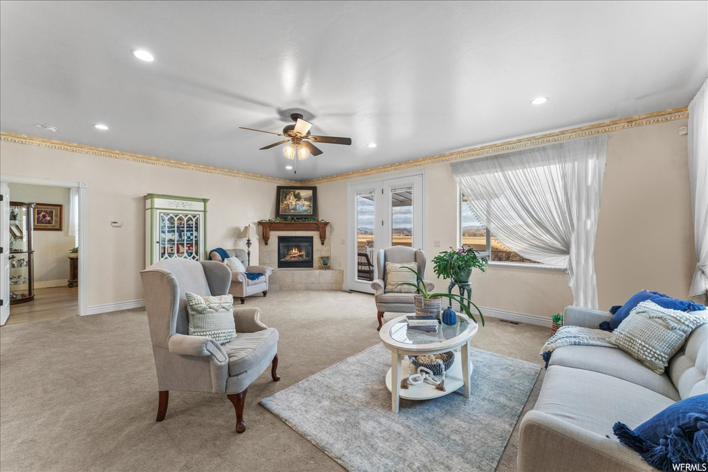Living room with light carpet, a tile fireplace, and ceiling fan
