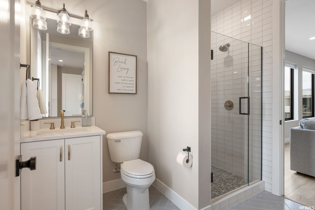 Bathroom with vanity, a shower with door, toilet, and hardwood / wood-style flooring