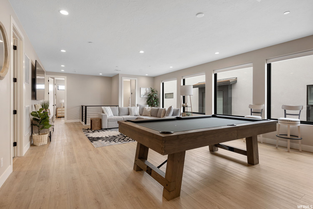 Game room featuring billiards, a wealth of natural light, and light hardwood / wood-style flooring