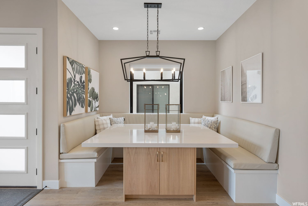 Dining space with light hardwood / wood-style flooring and a notable chandelier