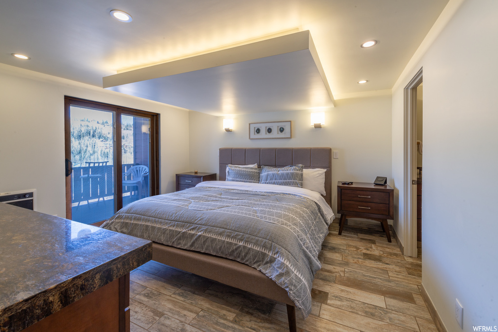 Bedroom with access to outside and dark hardwood / wood-style floors