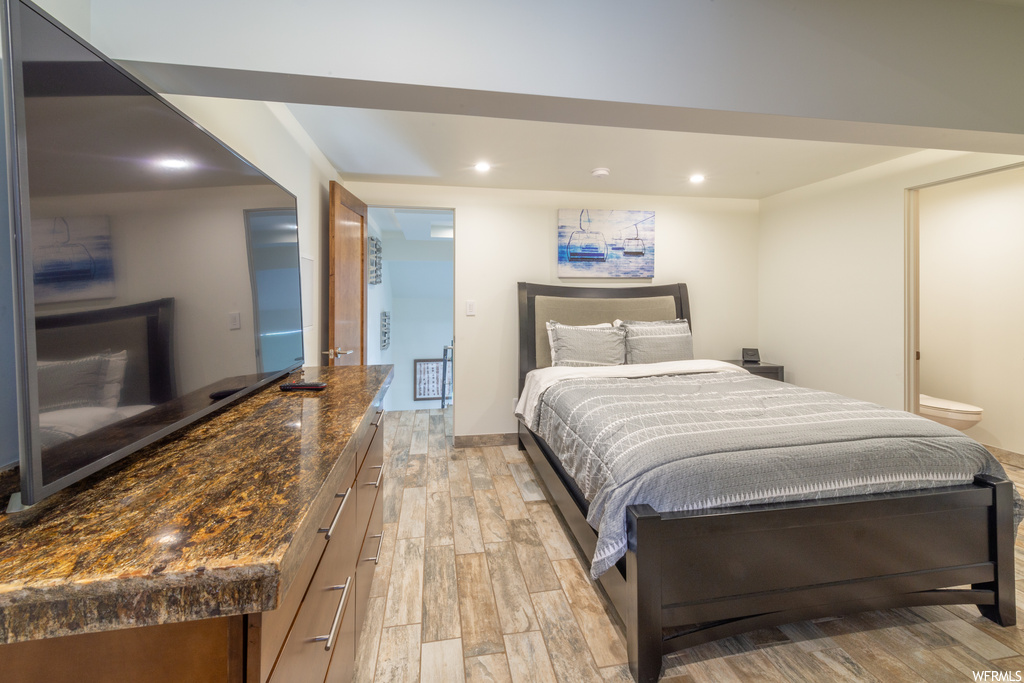 Bedroom featuring ensuite bathroom and light wood-type flooring