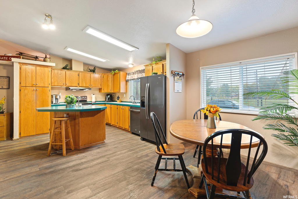 Kitchen featuring decorative light fixtures, hardwood / wood-style floors, and vaulted ceiling