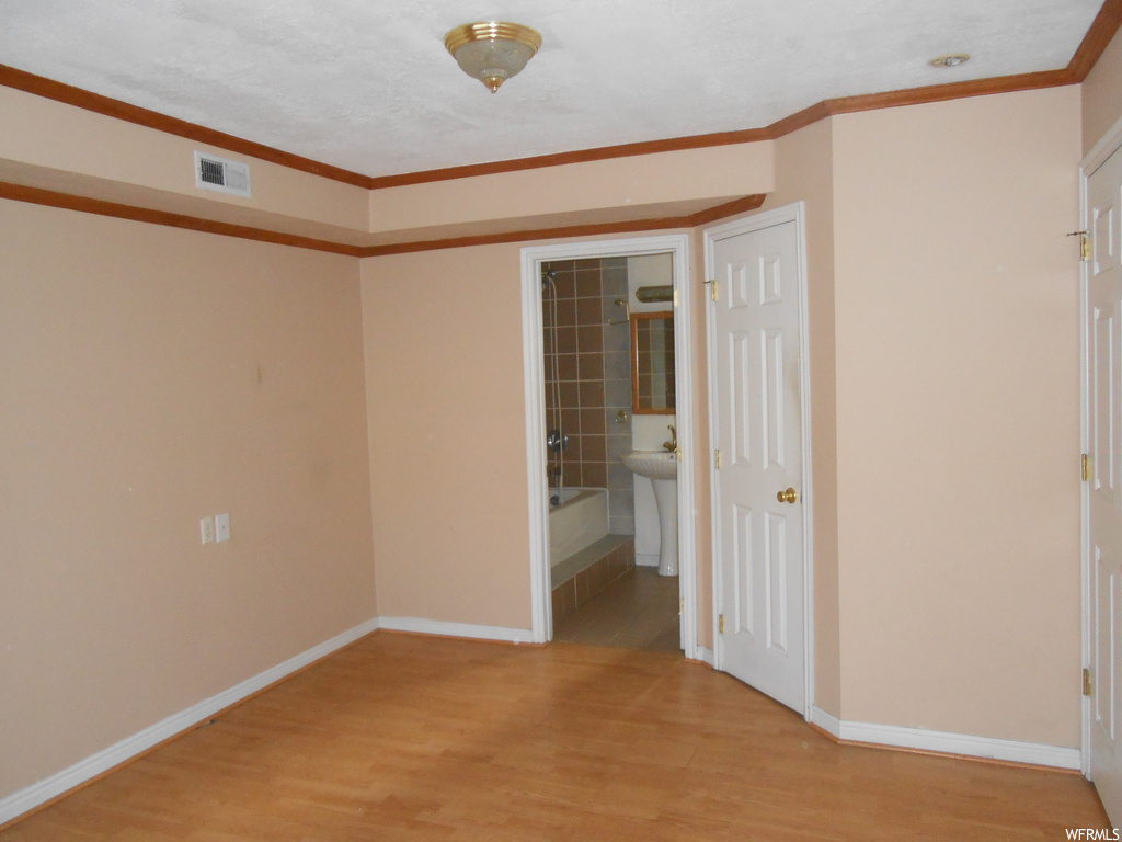 Unfurnished room featuring ornamental molding and light hardwood / wood-style flooring