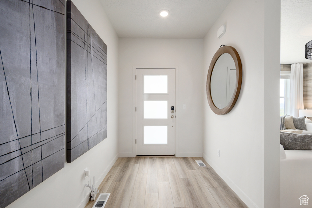 Interior space with a wealth of natural light and light hardwood / wood-style flooring