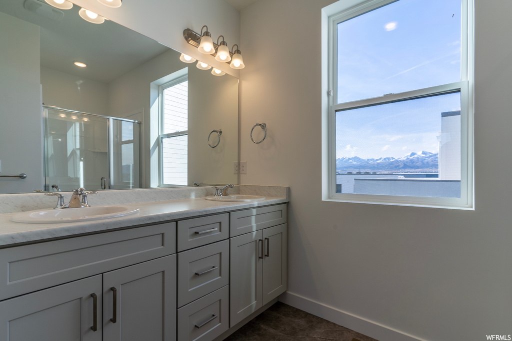 Bathroom with a mountain view, walk in shower, tile floors, and dual bowl vanity