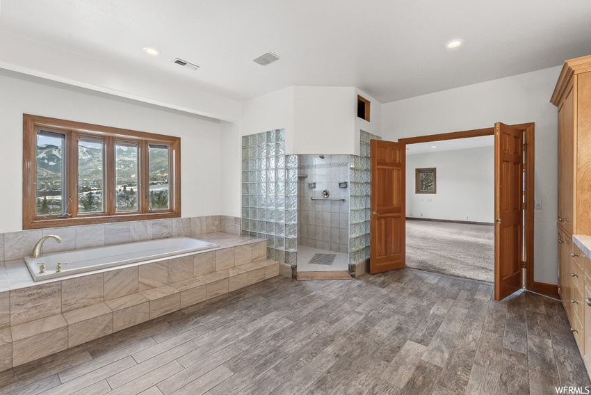 Bathroom with independent shower and bath, vanity, and hardwood / wood-style flooring
