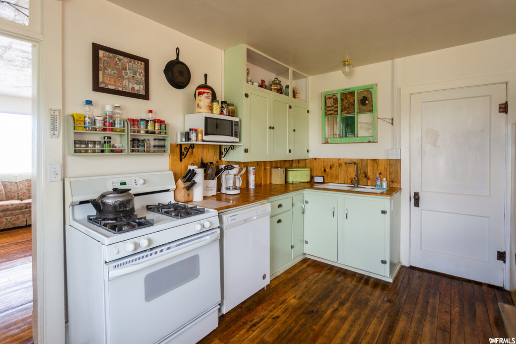 Kitchen featuring dark hardwood / wood-style floors, sink, and white appliances