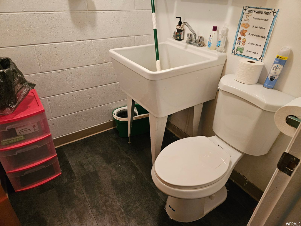 Bathroom featuring toilet, sink, and hardwood / wood-style flooring