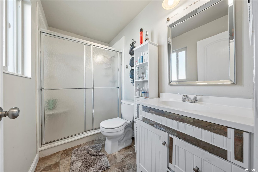 Bathroom with walk in shower, toilet, tile floors, and oversized vanity