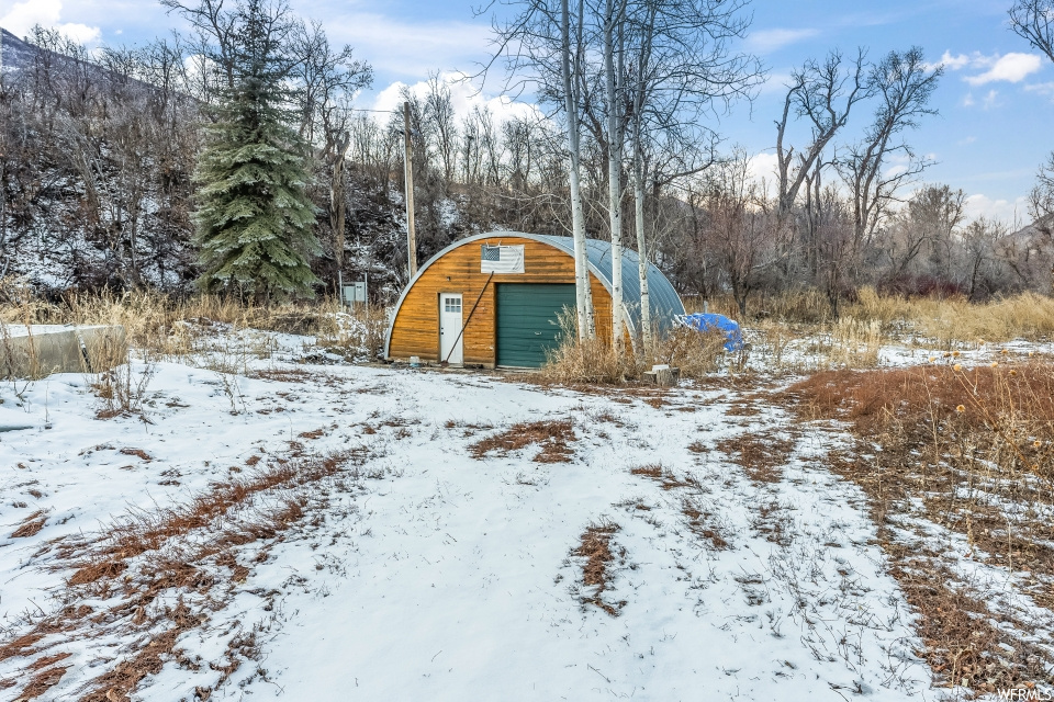 Snow covered structure featuring a garage