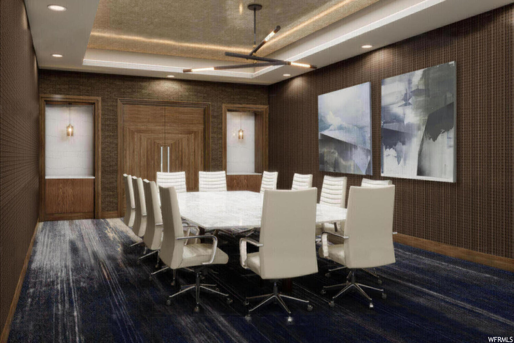 Dining space with a tray ceiling and dark hardwood / wood-style flooring