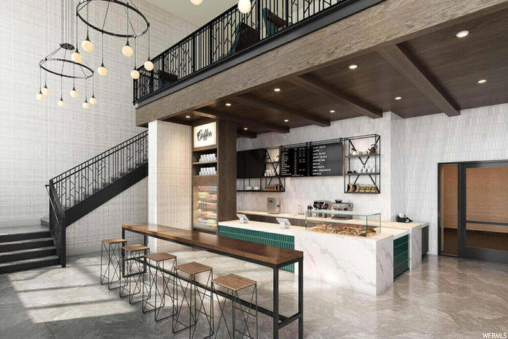 Kitchen featuring wood ceiling, beamed ceiling, a kitchen island with sink, light stone countertops, and a towering ceiling