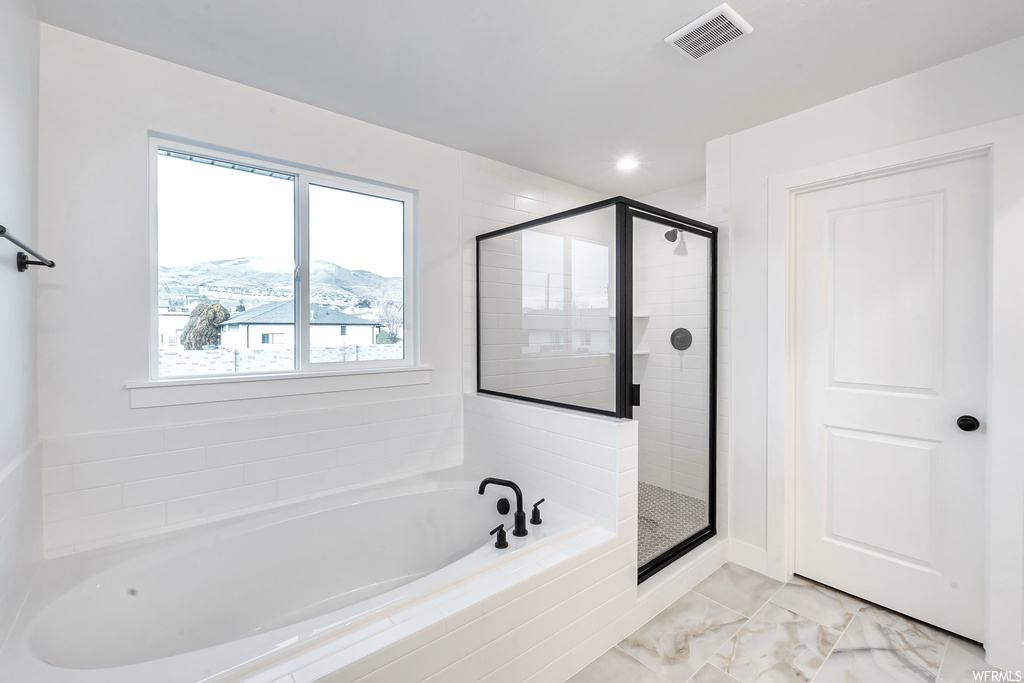 Bathroom featuring separate shower and tub, tile floors, and a mountain view