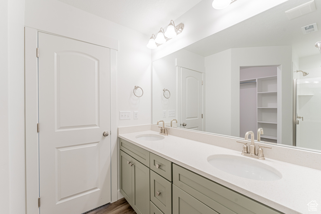 Bathroom featuring hardwood / wood-style floors, oversized vanity, and double sink