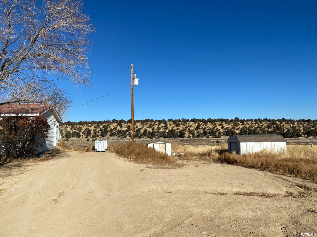 View of yard with a storage unit and a rural view