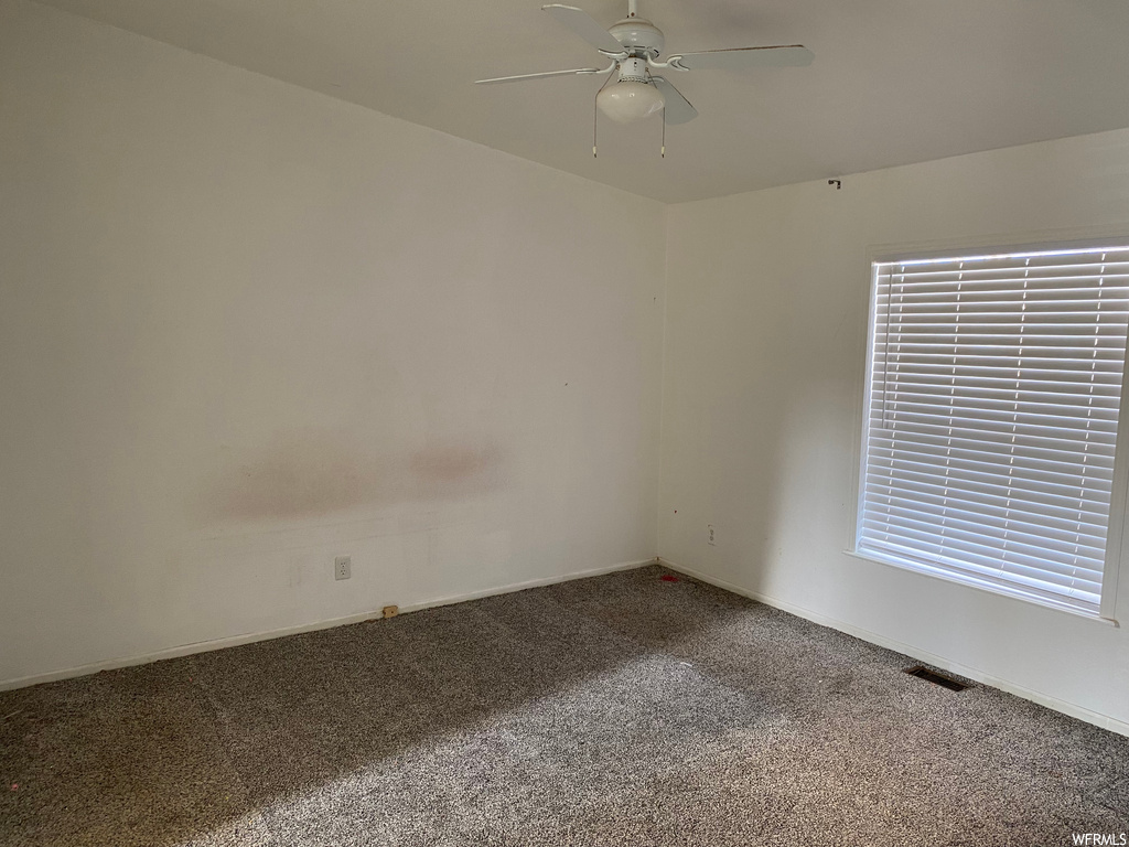 Unfurnished room with ceiling fan and carpet floors