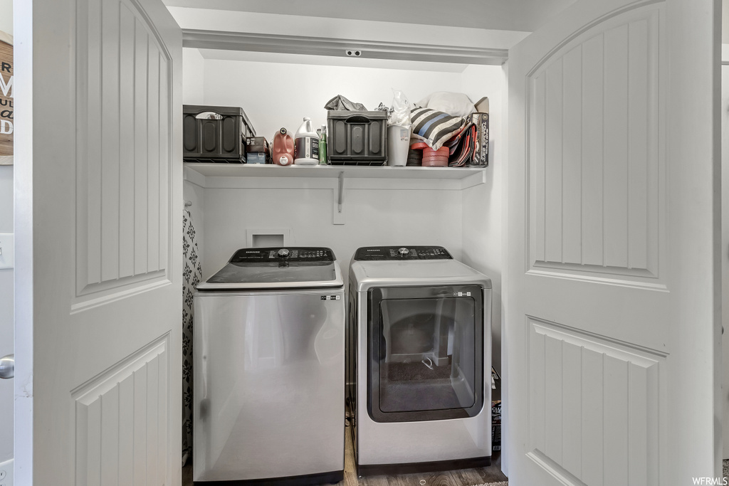 Laundry room with dark hardwood / wood-style floors and washing machine and dryer
