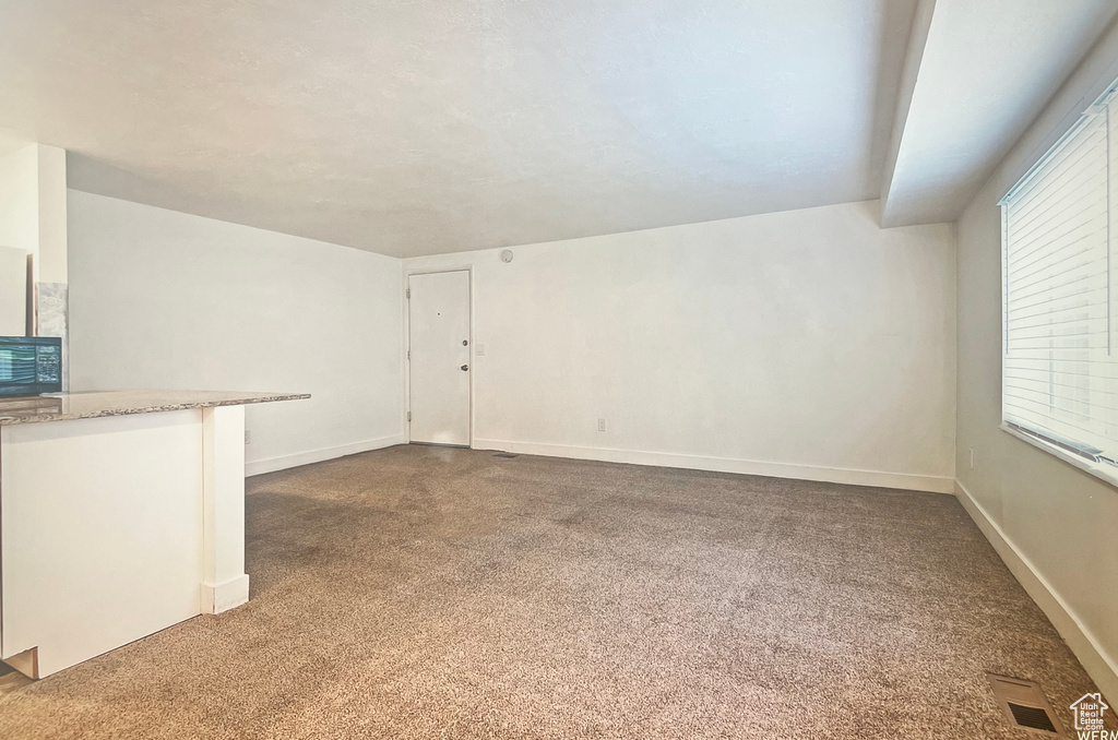 Unfurnished living room with dark colored carpet