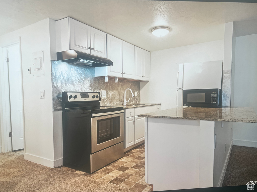 Kitchen featuring white cabinetry, dark stone countertops, backsplash, stainless steel electric range, and fridge
