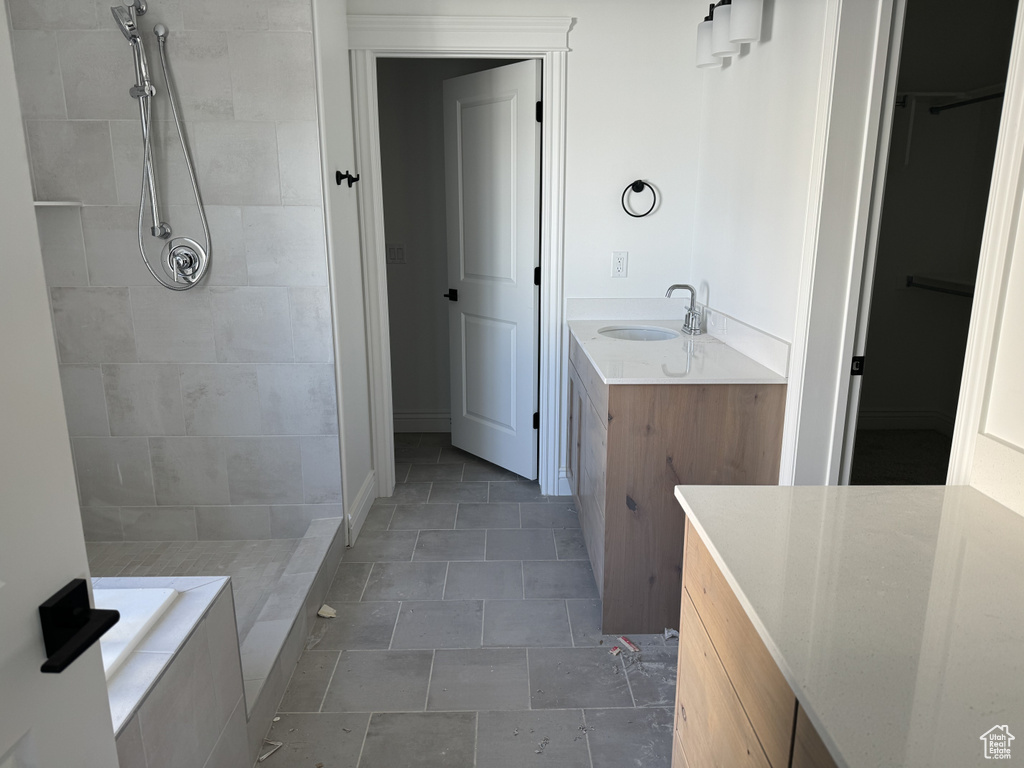 Bathroom featuring tiled shower, tile floors, and vanity