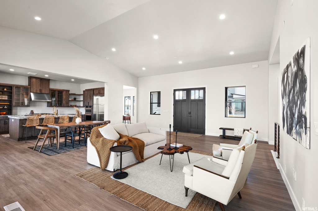 Living room featuring dark hardwood / wood-style floors, sink, and vaulted ceiling