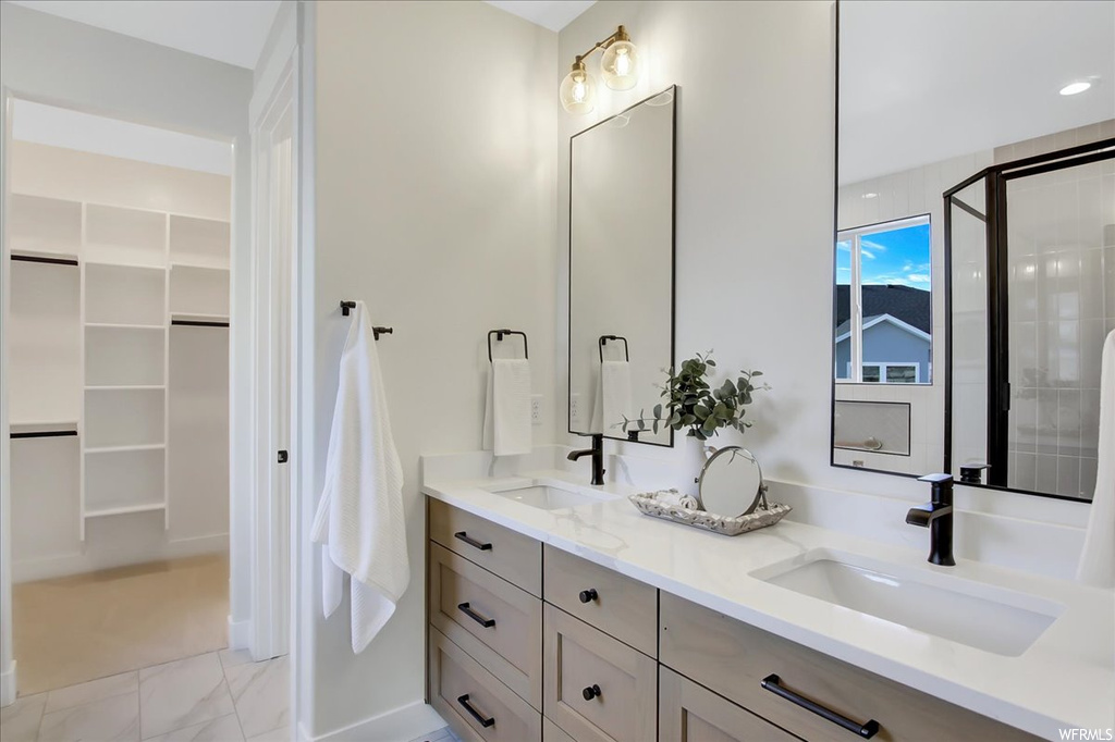 Bathroom featuring double sink, tile floors, and large vanity