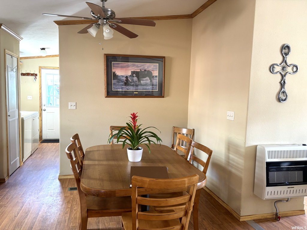 Dining area with ceiling fan, wood-type flooring, and crown molding