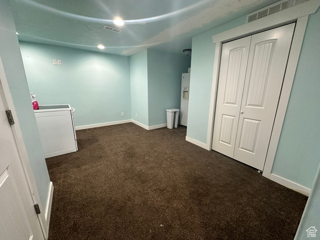 Interior space with a closet, washer / clothes dryer, and dark colored carpet
