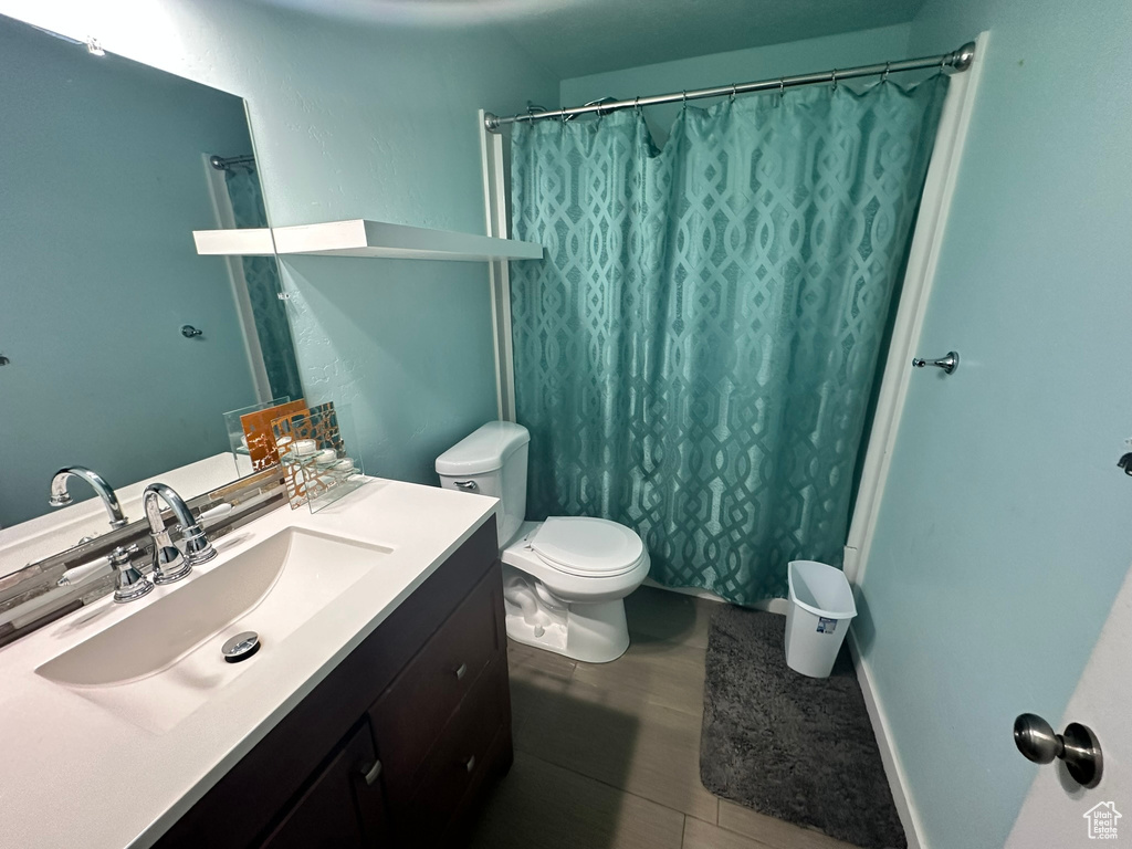 Bathroom with oversized vanity, toilet, and tile flooring