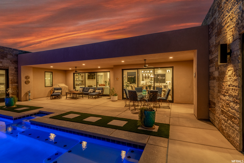 Pool at dusk featuring a patio, an in ground hot tub, and an outdoor living space