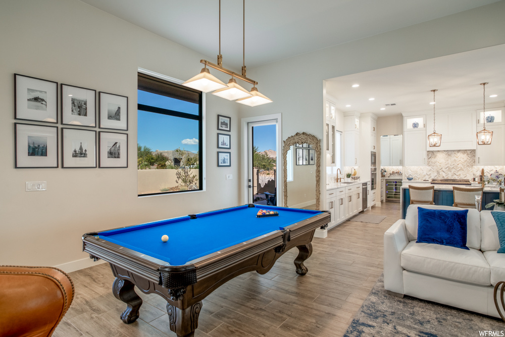 Recreation room featuring sink, light wood-type flooring, and pool table