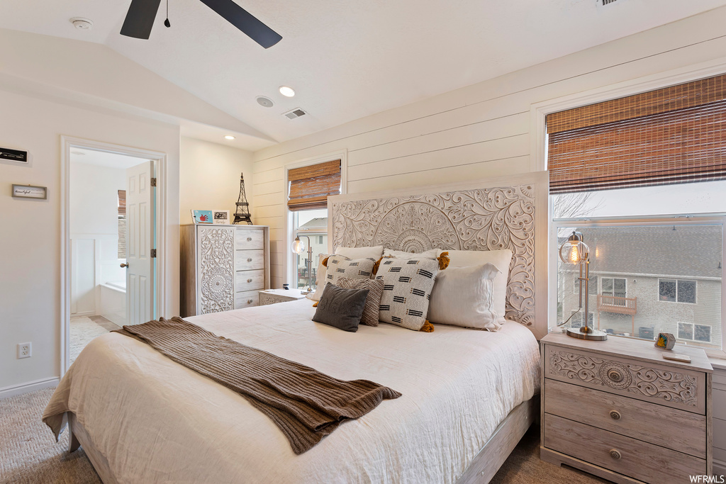 Carpeted bedroom featuring lofted ceiling, ceiling fan, and connected bathroom