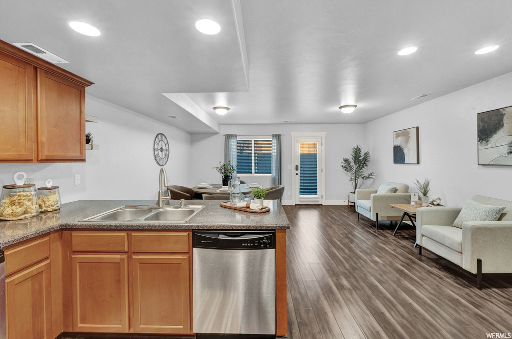 Kitchen featuring dark hardwood / wood-style floors, sink, dishwasher, and kitchen peninsula