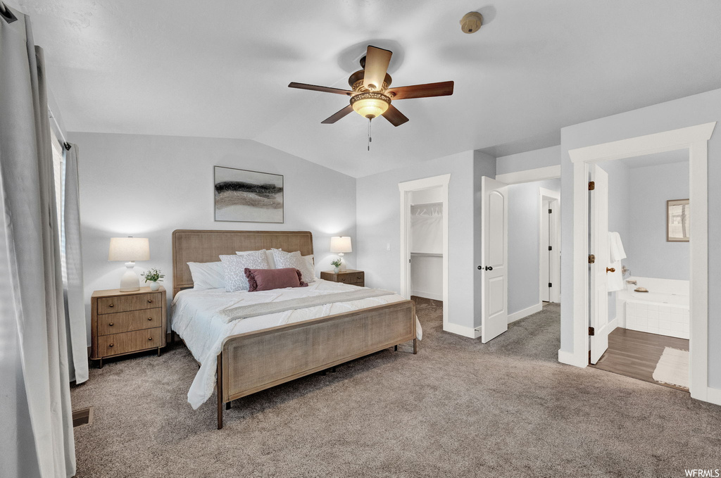 Bedroom with ceiling fan, light wood-type flooring, ensuite bath, and vaulted ceiling