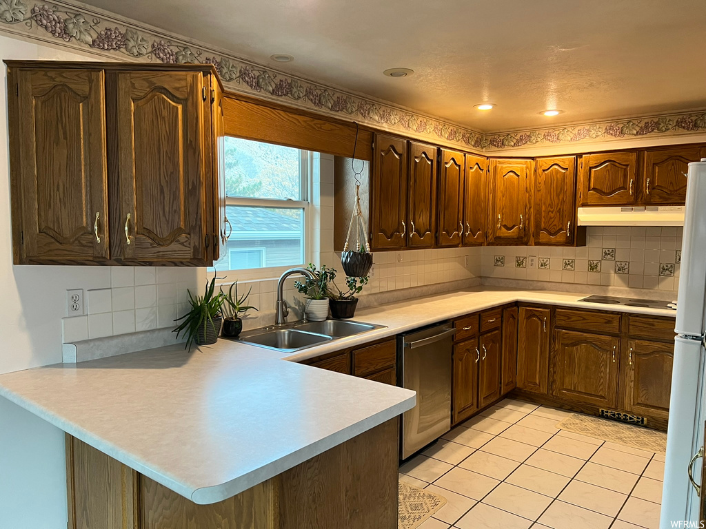 Kitchen featuring light tile flooring, sink, stainless steel dishwasher, tasteful backsplash, and electric stovetop