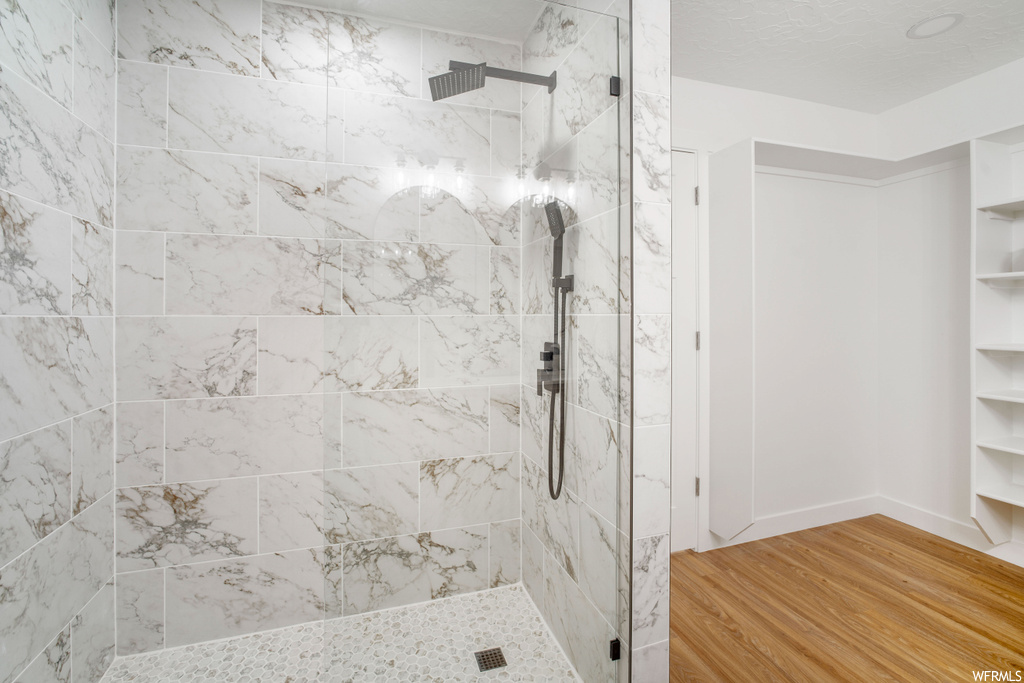 Bathroom featuring tiled shower and hardwood / wood-style floors