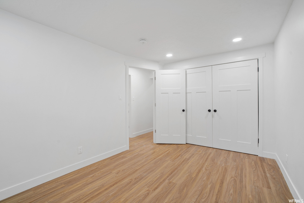 Unfurnished bedroom with light wood-type flooring and a closet