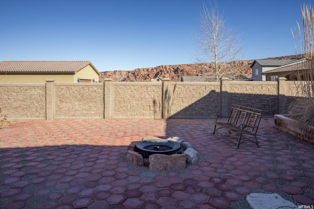 View of patio / terrace with a fire pit and a mountain view