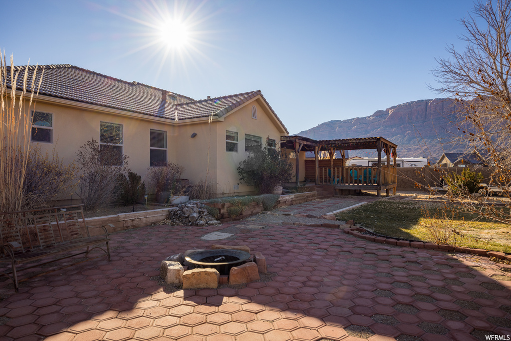 View of patio / terrace with a pergola, an outdoor fire pit, and a mountain view