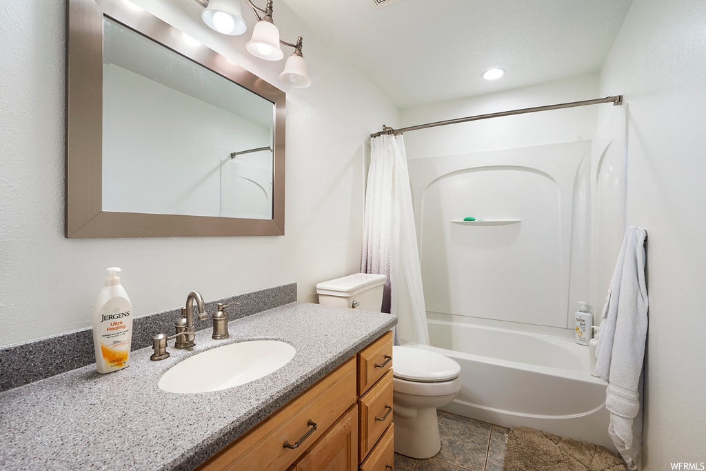 Full bathroom featuring toilet, tile flooring, vanity, and shower / tub combo with curtain