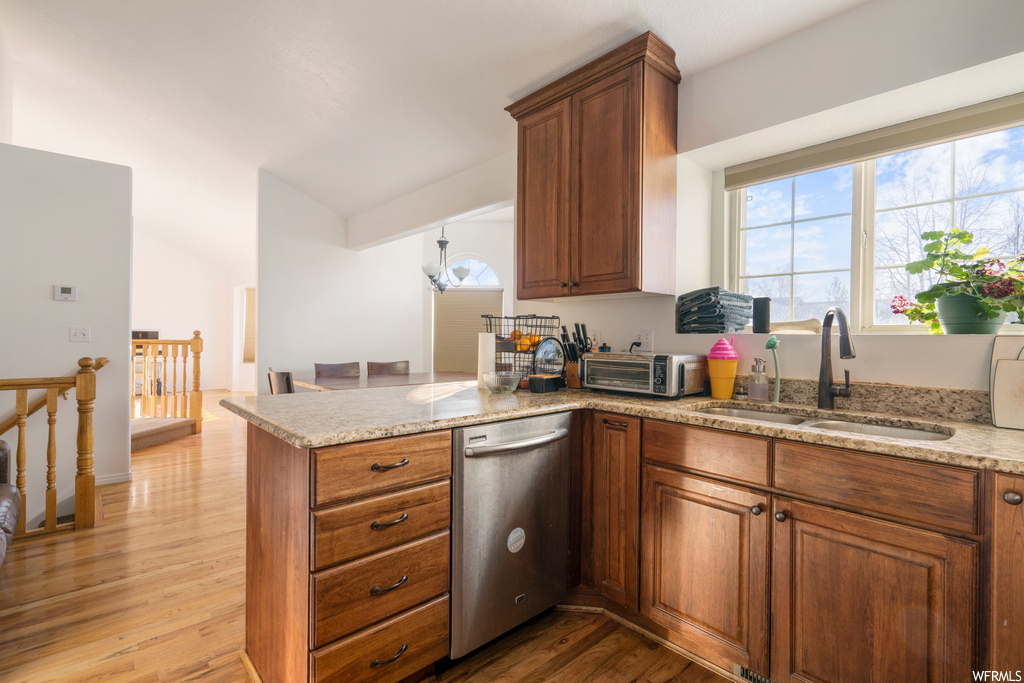 Kitchen with light hardwood / wood-style flooring, stainless steel dishwasher, a healthy amount of sunlight, and sink