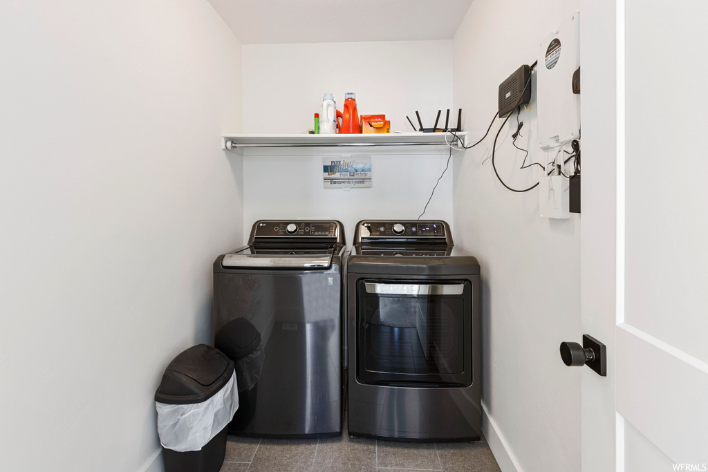 Laundry area featuring washer and dryer and dark tile flooring