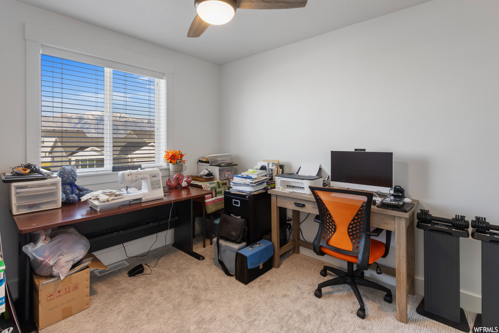 Office area featuring light colored carpet and ceiling fan