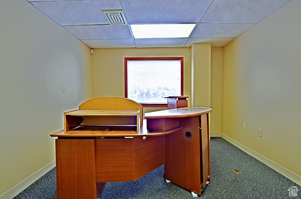 Office with bar area, a drop ceiling, and dark colored carpet