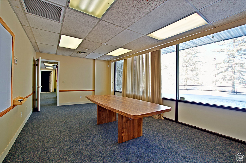 Unfurnished office featuring a paneled ceiling and dark carpet