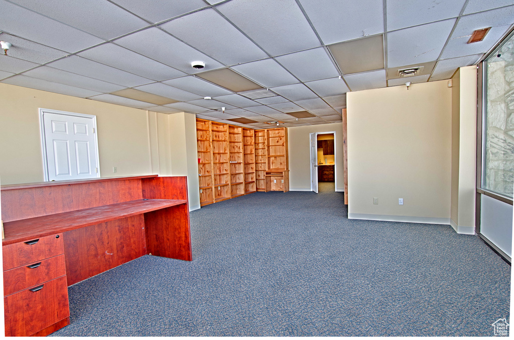 Unfurnished office with dark carpet and a paneled ceiling