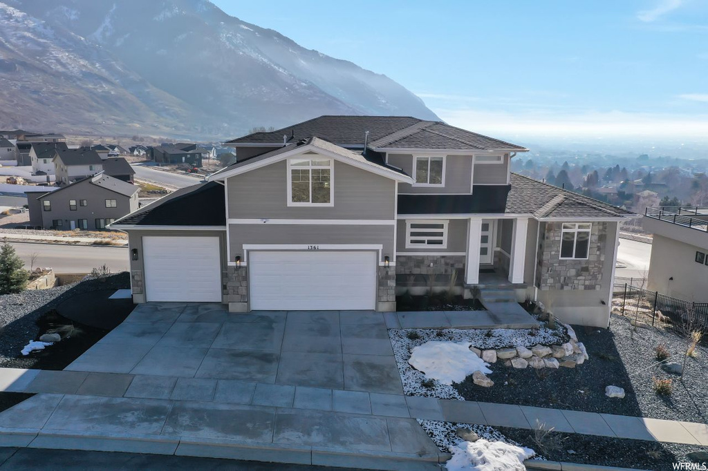 View of front property with a garage and a mountain view